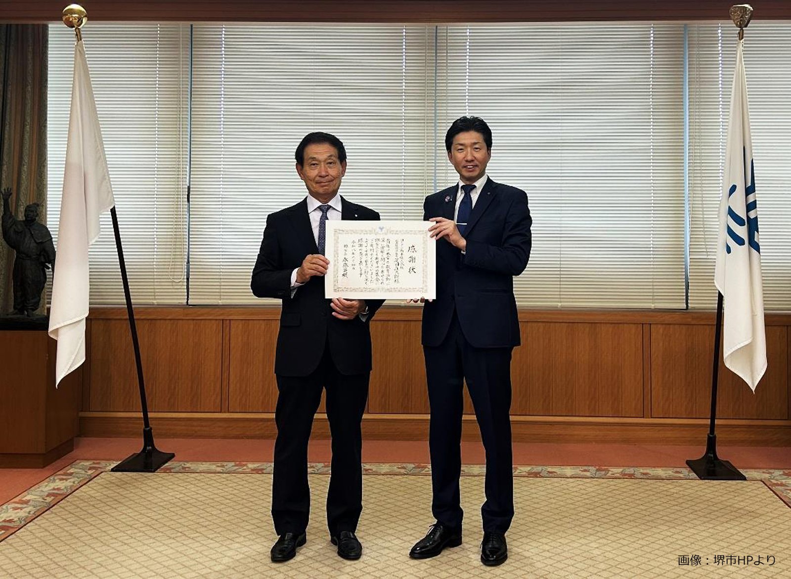 コーナン商事の疋田直太郎代表取締役社長と永藤英機堺市長が感謝状を持って並ぶ様子｜堺市のニュースならサカイタイムズ