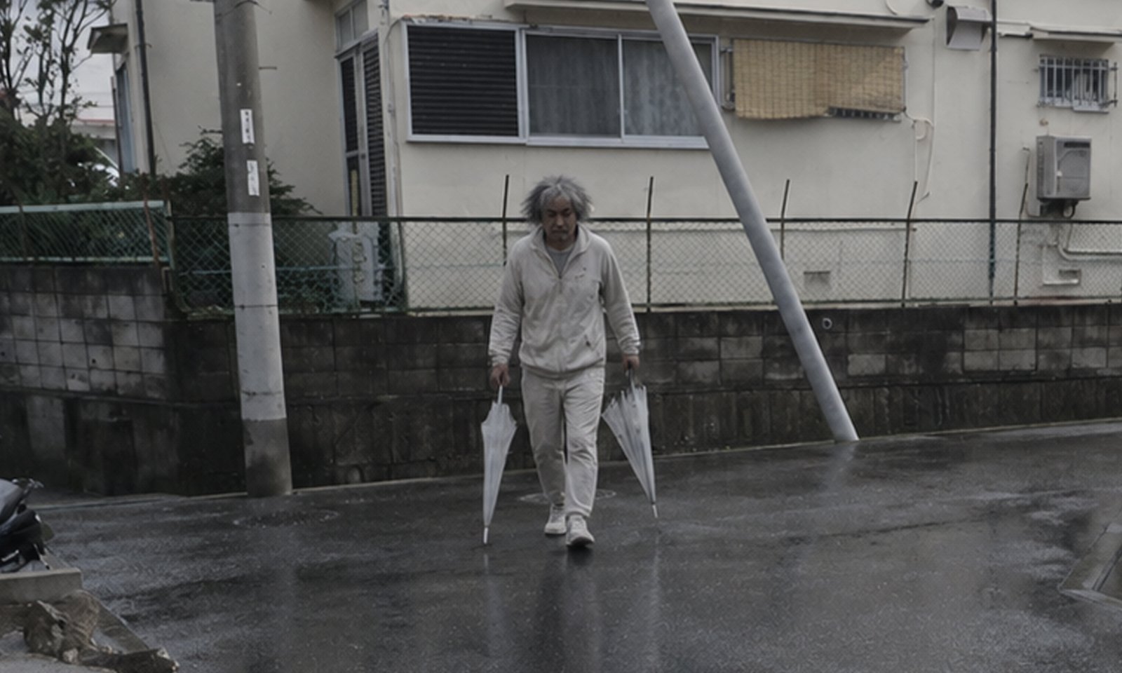 年齢60歳位、白色パーカー、白髪交じりの黒色頭髪、透明ビニール傘を2本所持した不審者のイメージ画像
