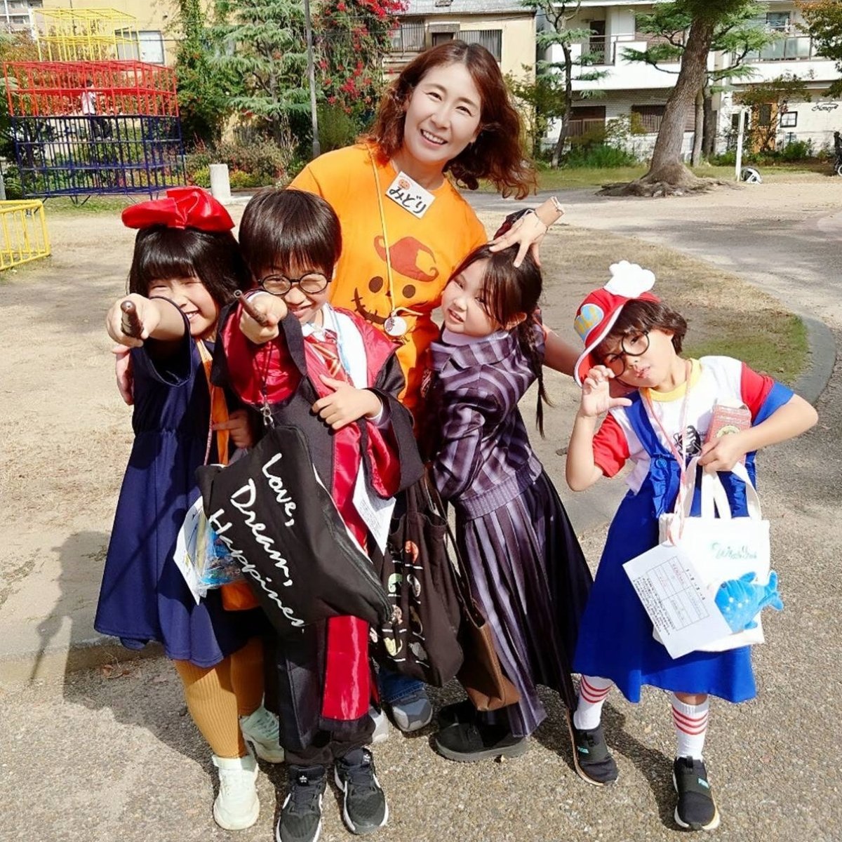 仮装した子どもたちと屋外で笑顔を見せる伊藤みどりさん
