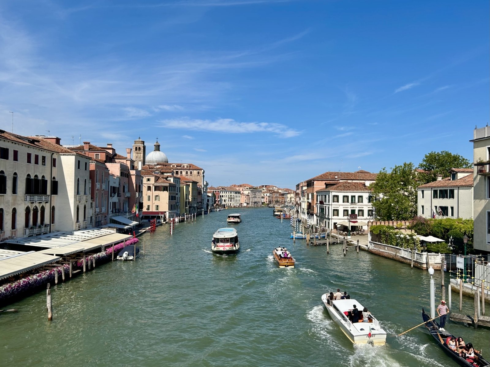 歴史的な建物が並ぶイタリア・ヴェネツィアの運河を複数の船が行き交う風景