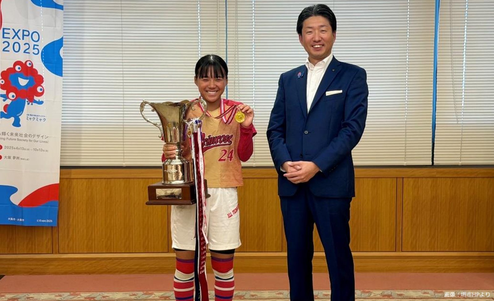 全日本中学生女子ソフトボール大会で優勝した川端理央選手が、堺市役所で優勝トロフィーと金メダルを手に永藤英機市長と並んで記念撮影している様子