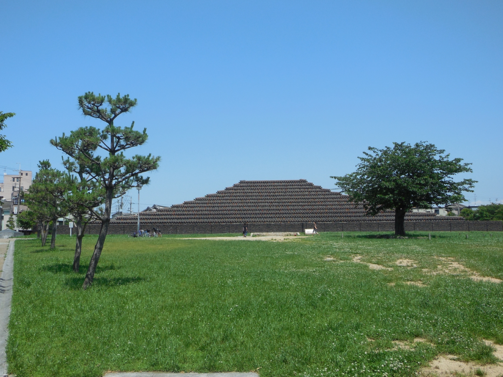 堺市中区の土塔町公園にある史跡土塔。広い芝生と樹木の向こうに、瓦を積み上げた階段状の塔が見える風景