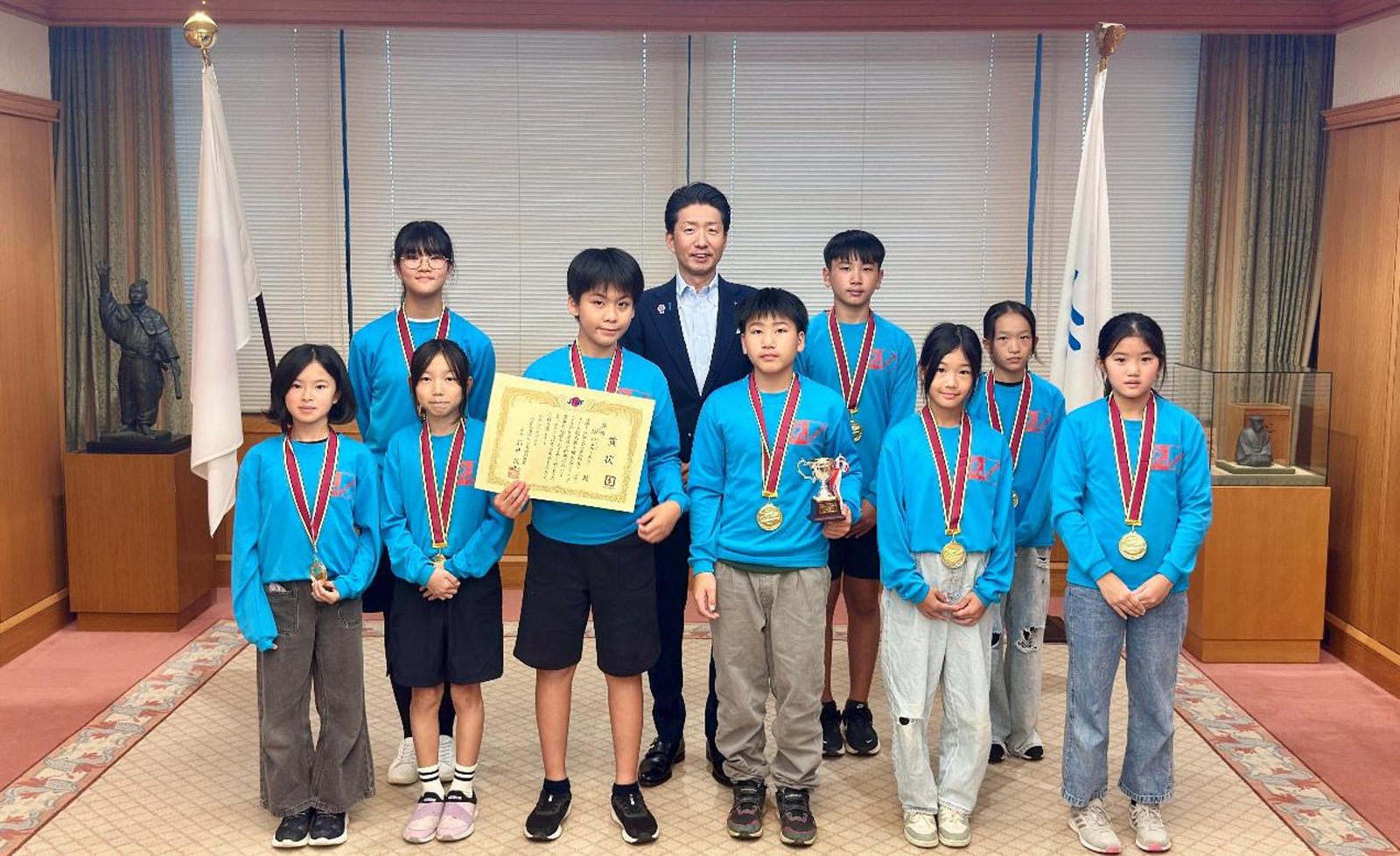 全日本ジュニア・ユース綱引選手権大会で優勝した堺Homiesの選手9人と永藤英機市長の記念写真